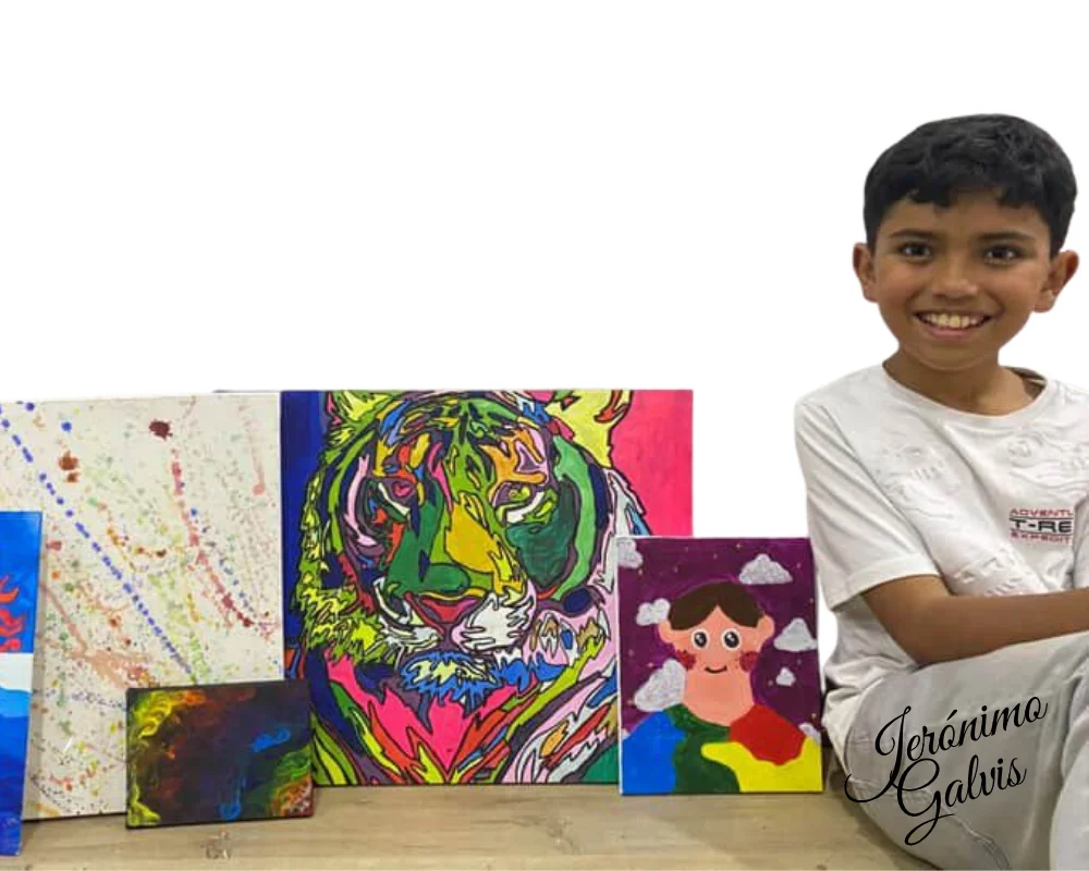 Jerónimo Galvis sentado junto a sus pinturas originales, con su firma — artista infantil colombiano